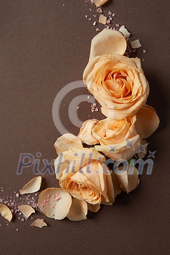 Decoration of orange flowers and petals over brown background Decoration of orange flowers and petals over brown background