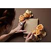 Woman writing love sign in notepad with orange roses
