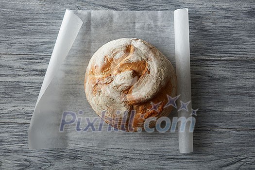 Top view of homemade bread on baking paper over wooden table Top view of homemade bread on baking paper over wooden table