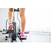 Young woman's muscular legs on stepper/treadmill, closeup