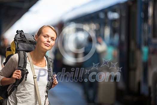 Pretty young woman boarding a train/having arrived to her destination, waiting for her friends to pick her up (color toned image) Pretty young woman boarding a train/having arrived to her destination, waiting for her friends to pick her up (color toned image)