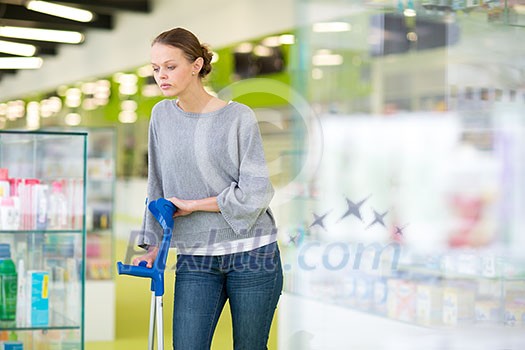 Young woman blowing her nose while in a modern pharmacy, choosing pills to help her with the flu/cold (shallow DOF; color toned image) Young woman blowing her nose while in a modern pharmacy, choosing pills to help her with the flu/cold (shallow DOF; color toned image)