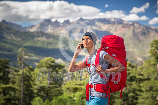 Female hiker in high mountains calling with her cell phone - trying to get some signal Female hiker in high mountains calling with her cell phone - trying to get some signal