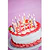 Birthday cake with burning candles on a plate on pink background