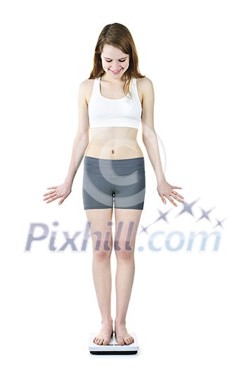Happy fit young woman standing on bathroom scale looking down Happy fit young woman standing on bathroom scale looking down