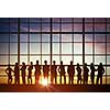 Silhouette of business people of different professions on sunset background