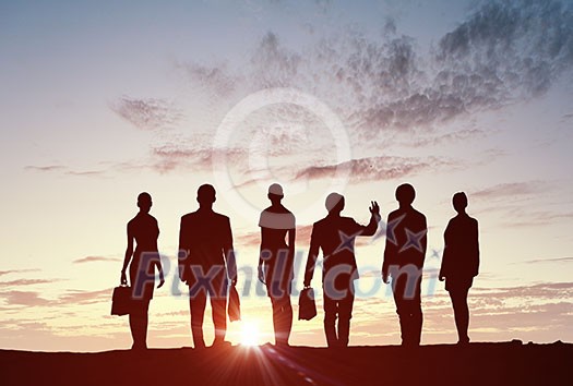 Silhouette of business people of different professions on sunset background Silhouette of business people of different professions on sunset background