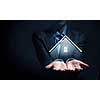 Close up of businesswoman holding real estate icon in palm on dark background