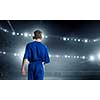 Rear view of kid boy in blue uniform on soccer stadium