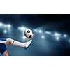 Leg of kid boy in blue uniform on soccer stadium kicking ball