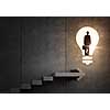 Back view of businessman standing on ladder and big idea bulb