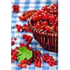 Redcurrant red currant berries  in wicker bowl on kitchen table