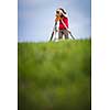 Young, female land surveyor at work - using the theodolite level outdoors