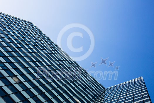 Exterior of building - abstract concept; skyscraper from down below against blue sky Exterior of building - abstract concept; skyscraper from down below against blue sky