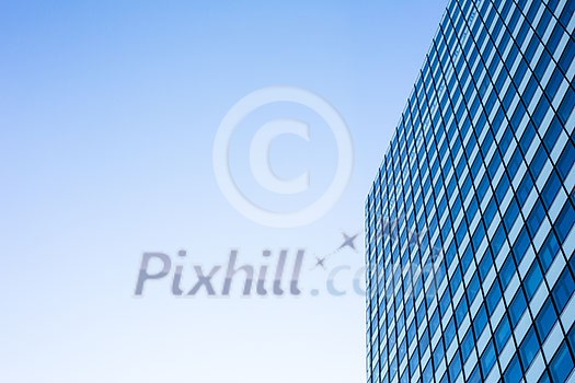 Exterior of building - abstract concept; skyscraper from down below against blue sky Exterior of building - abstract concept; skyscraper from down below against blue sky