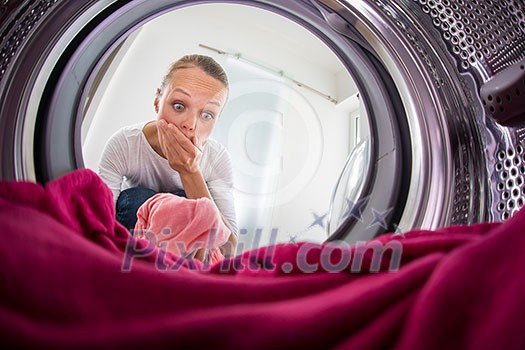 Young woman doing laundry - view from the washing machine Young woman doing laundry - view from the washing machine