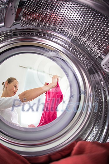 Young woman doing laundry - view from the washing machine Young woman doing laundry - view from the washing machine