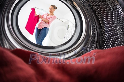 Young woman doing laundry - view from the washing machine Young woman doing laundry - view from the washing machine