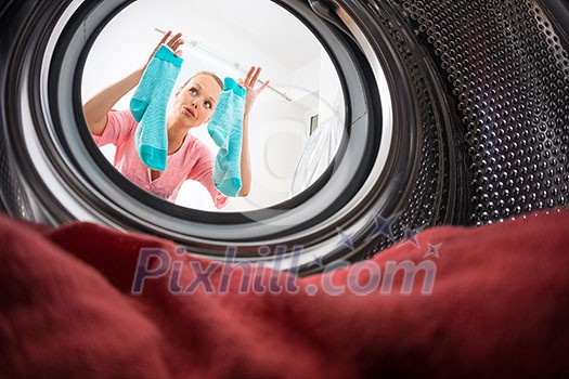 Young woman doing laundry - view from the washing machine Young woman doing laundry - view from the washing machine