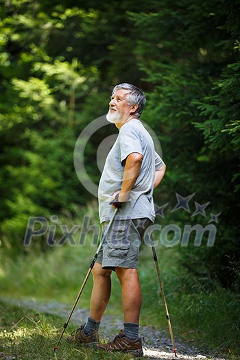 Active senior hiking in high mountains - taking a minute to admire the beauty of the nature, resting for a while Active senior hiking in high mountains - taking a minute to admire the beauty of the nature, resting for a while