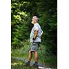 Active senior hiking in high mountains - taking a minute to admire the beauty of the nature, resting for a while