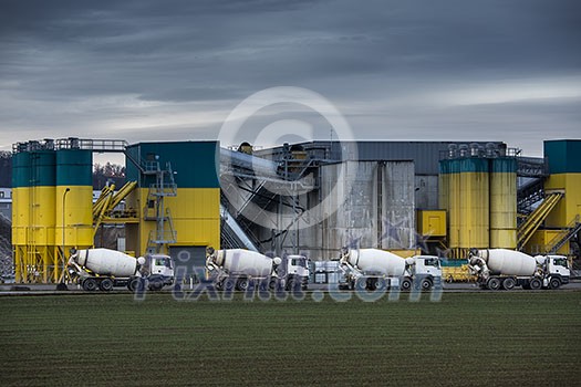 Concrete production plant/factory with Concrete mixing transport trucks in front of it Concrete production plant/factory with Concrete mixing transport trucks in front of it