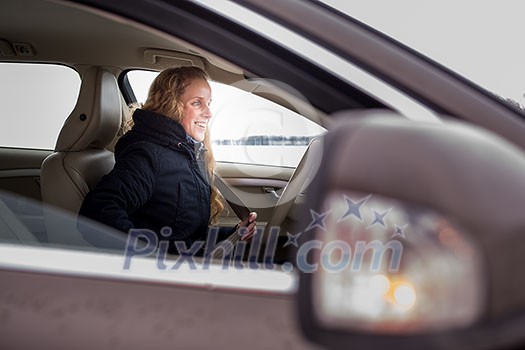 Woman driving a car - female driver at a wheel of a modern car (shallow DOF; color toned image) Woman driving a car - female driver at a wheel of a modern car (shallow DOF; color toned image)