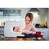 Beautiful young woman sewing clothes with sewing machine (color toned image; shallow DOF)