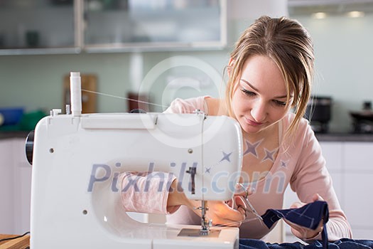 Beautiful young woman sewing clothes with sewing machine (color toned image; shallow DOF) Beautiful young woman sewing clothes with sewing machine (color toned image; shallow DOF)