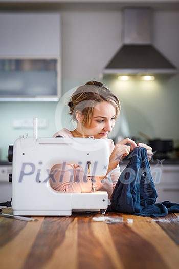 Beautiful young woman sewing clothes with sewing machine (color toned image; shallow DOF) Beautiful young woman sewing clothes with sewing machine (color toned image; shallow DOF)