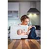 Beautiful young woman sewing clothes with sewing machine (color toned image; shallow DOF)