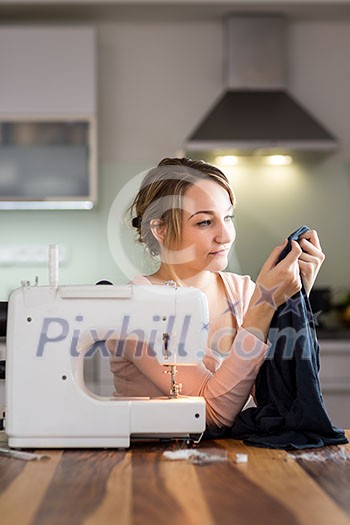 Beautiful young woman sewing clothes with sewing machine (color toned image; shallow DOF) Beautiful young woman sewing clothes with sewing machine (color toned image; shallow DOF)