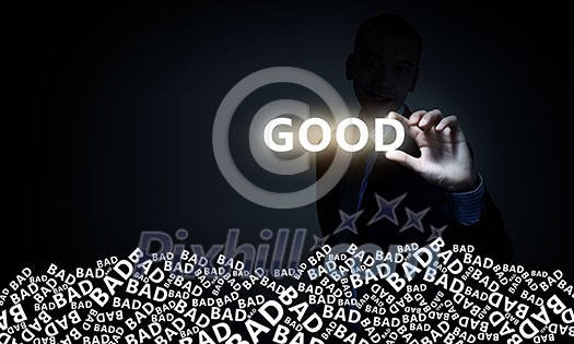 Businessman on dark background taking with fingers glowing word good Businessman on dark background taking with fingers glowing word good