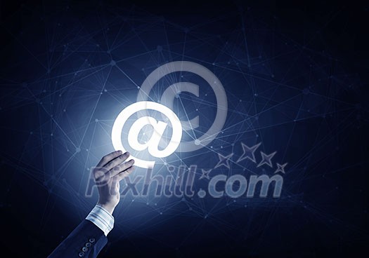 Businessman hand on dark digital background showing email sign Businessman hand on dark digital background showing email sign