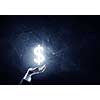 Businessman hands on dark background holding glowing dollar sign