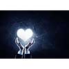 Businessman hands on dark background holding with care digital heart