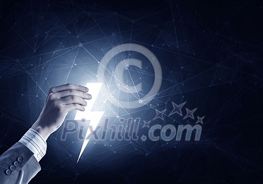 Hand of businessman on dark background holding glowing thunderbolt Hand of businessman on dark background holding glowing thunderbolt