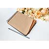 note pad with pen and beautiful bouquet on a white background ,