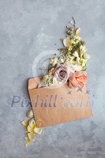 The message in the letter. Beautiful bouquet of flowers in an envelope on a stone gray background as a concept for the holiday, Flat lay. The message in the letter. Beautiful bouquet of flowers in an envelope on a stone gray background as a concept for the holiday, Flat lay.
