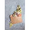 The message in the letter. Beautiful bouquet of flowers in an envelope on a stone gray background as a concept for the holiday, Flat lay.