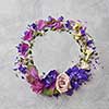 round frame of spring colored flowers on a gray background
