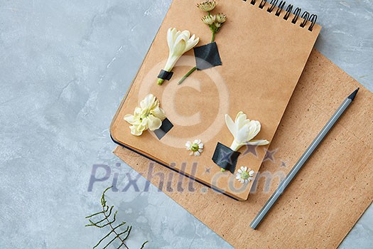Top view of craft notebook with flower decoration with pencil on concrete background, overhead view Top view of craft notebook with flower decoration with pencil on concrete background, overhead view