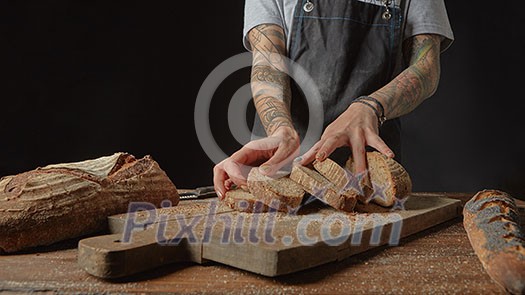 Woman with tattoos on her hands with fresh bread on wooden table Woman with tattoos on her hands with fresh bread on wooden table