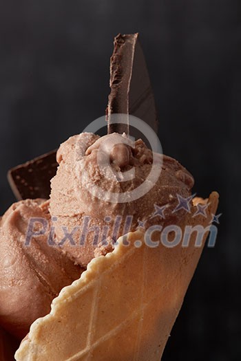 Chocolate ice cream with pieces of chocolate in a waffle cone close up Chocolate ice cream with pieces of chocolate in a waffle cone close up