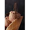 Chocolate ice cream with pieces of chocolate in a waffle cone close up