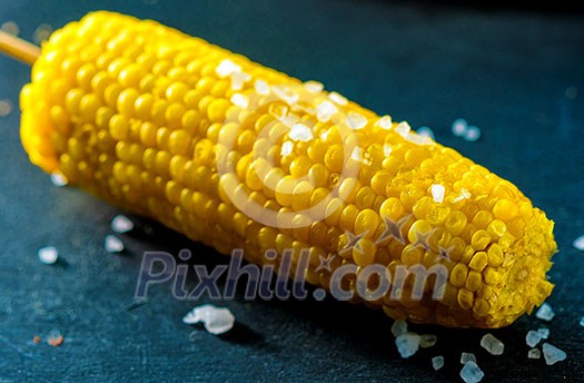 Boiled fresh corn with salt on the table Boiled fresh corn with salt on the table