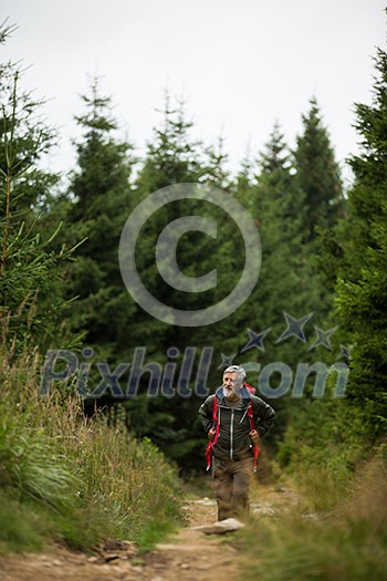 Active senior hiking in high mountains - enjoying his retirement in an active way Active senior hiking in high mountains - enjoying his retirement in an active way