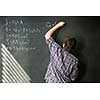 College student solving a math problem during math class in front of the blackboard/chalkboard (color toned image)