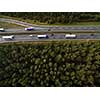 Aerial view of a highway amid fields with cars on it