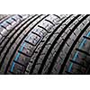 Stack of brand new high performance car tires on clean high-key white studio background